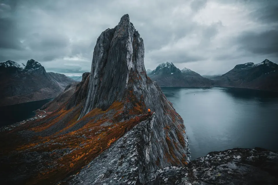 Fjelltoppen Segla på Senja med fjord og snødekte tinder under grå skyer